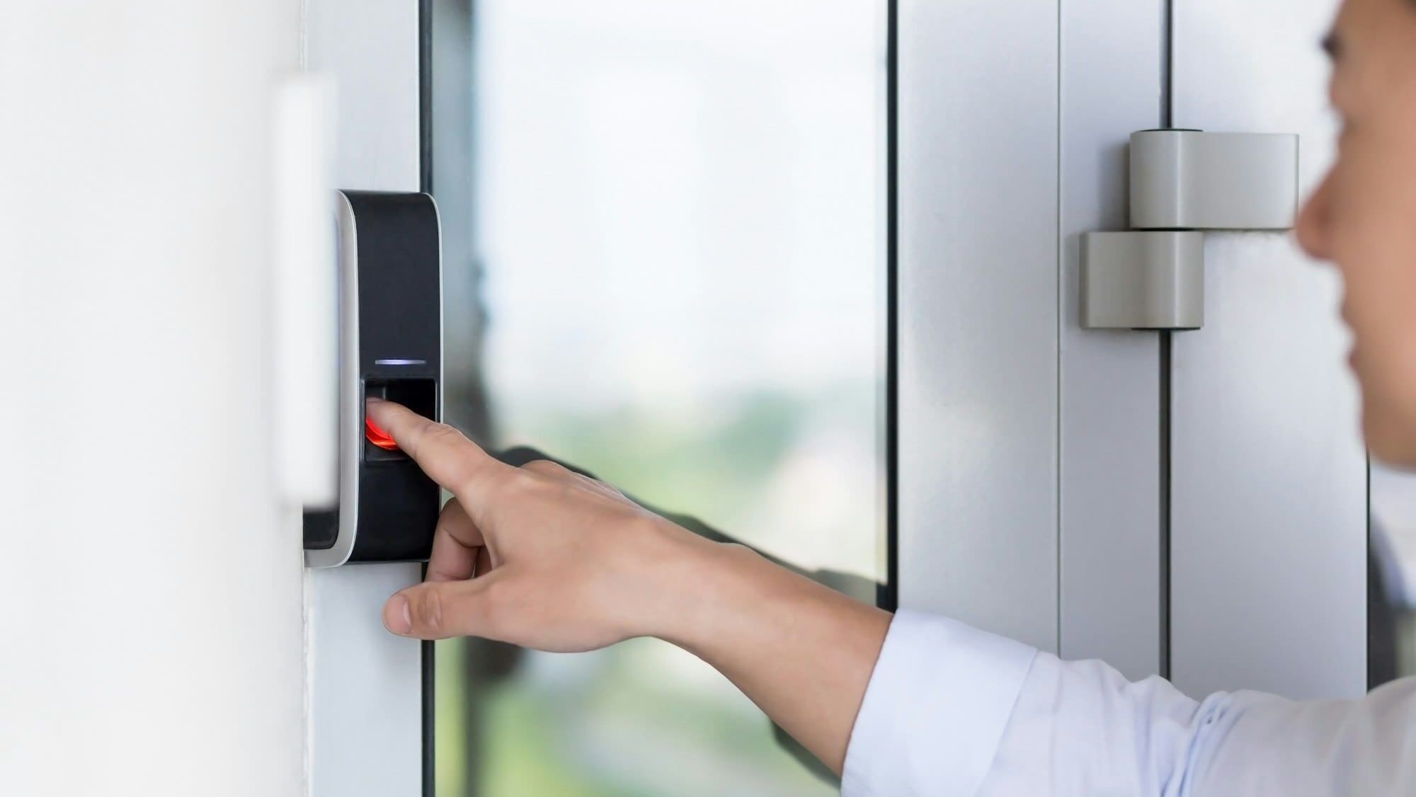 Asian businessman's hand using fingerprint sensor door lock, modern doorbell with video camera