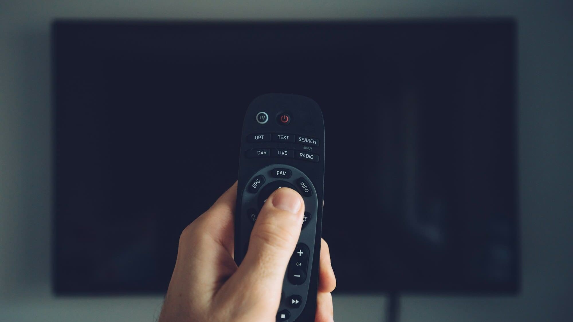 Male hand with TV remote controller