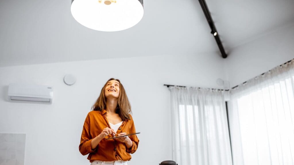 Woman controlling light with a smart home at home for intelligent lighting trends and innovations