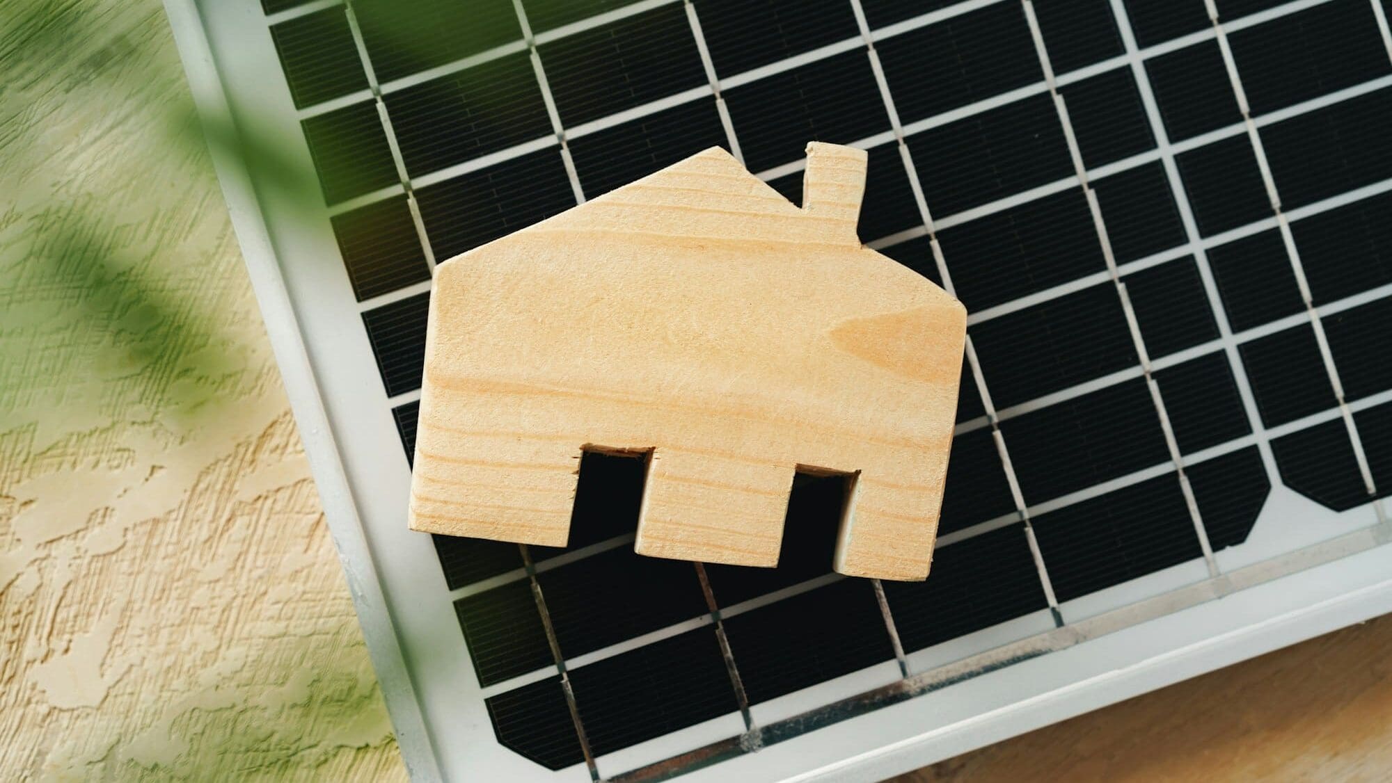 Wooden house miniature and solar panel close up