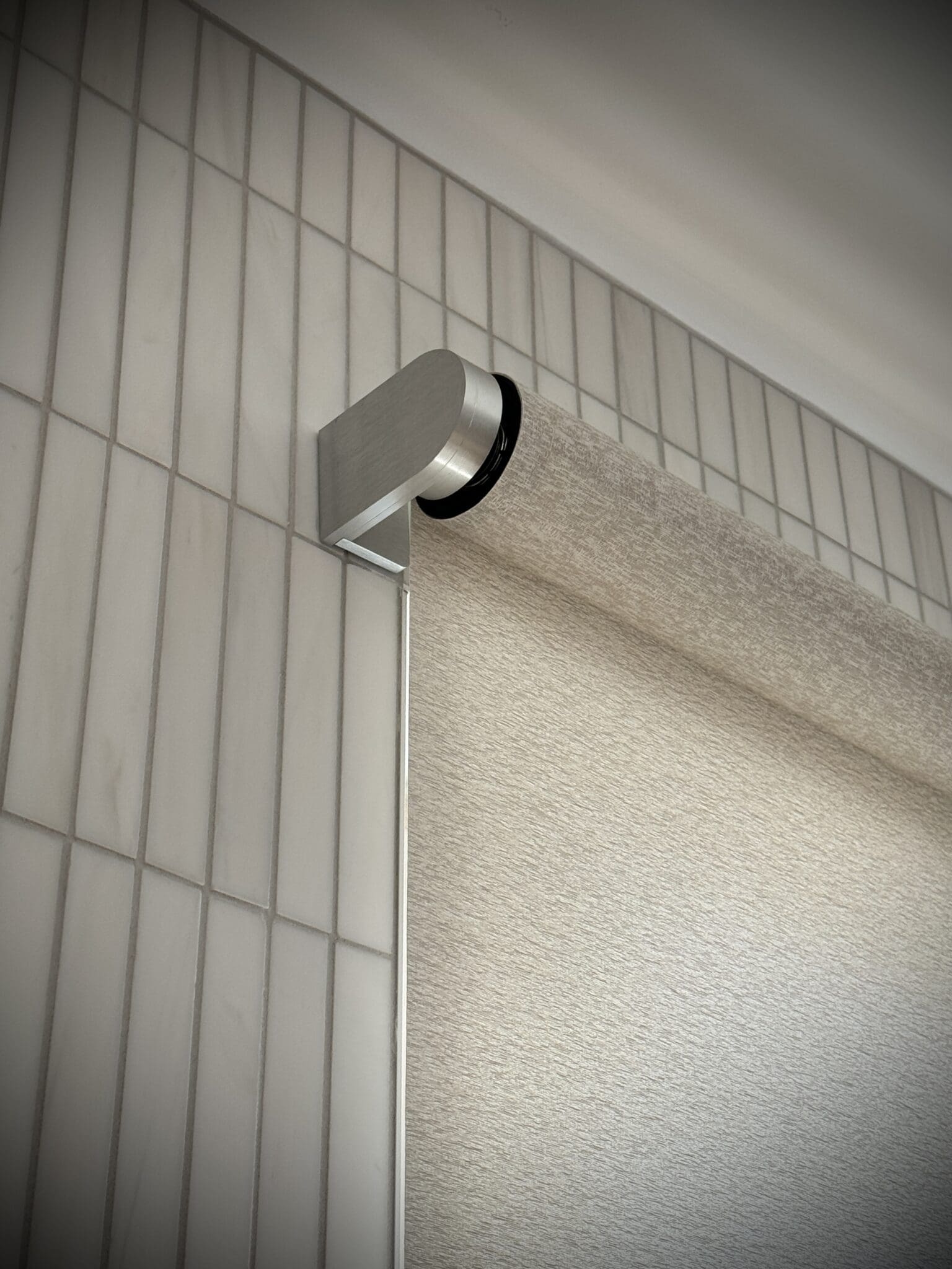 Lutron Palladiom shade bracket against a tiled wall
