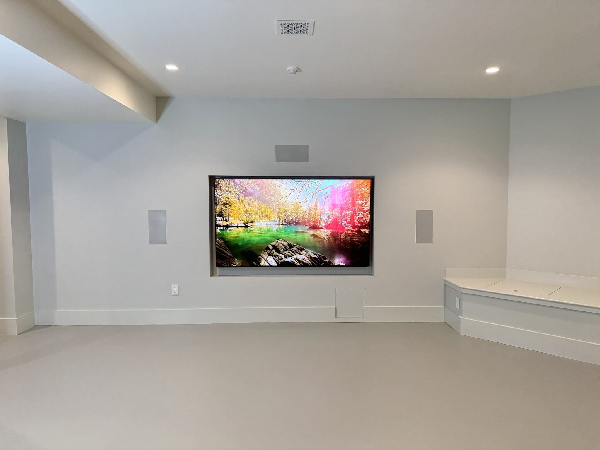 Basement media room with a wall-mounted TV