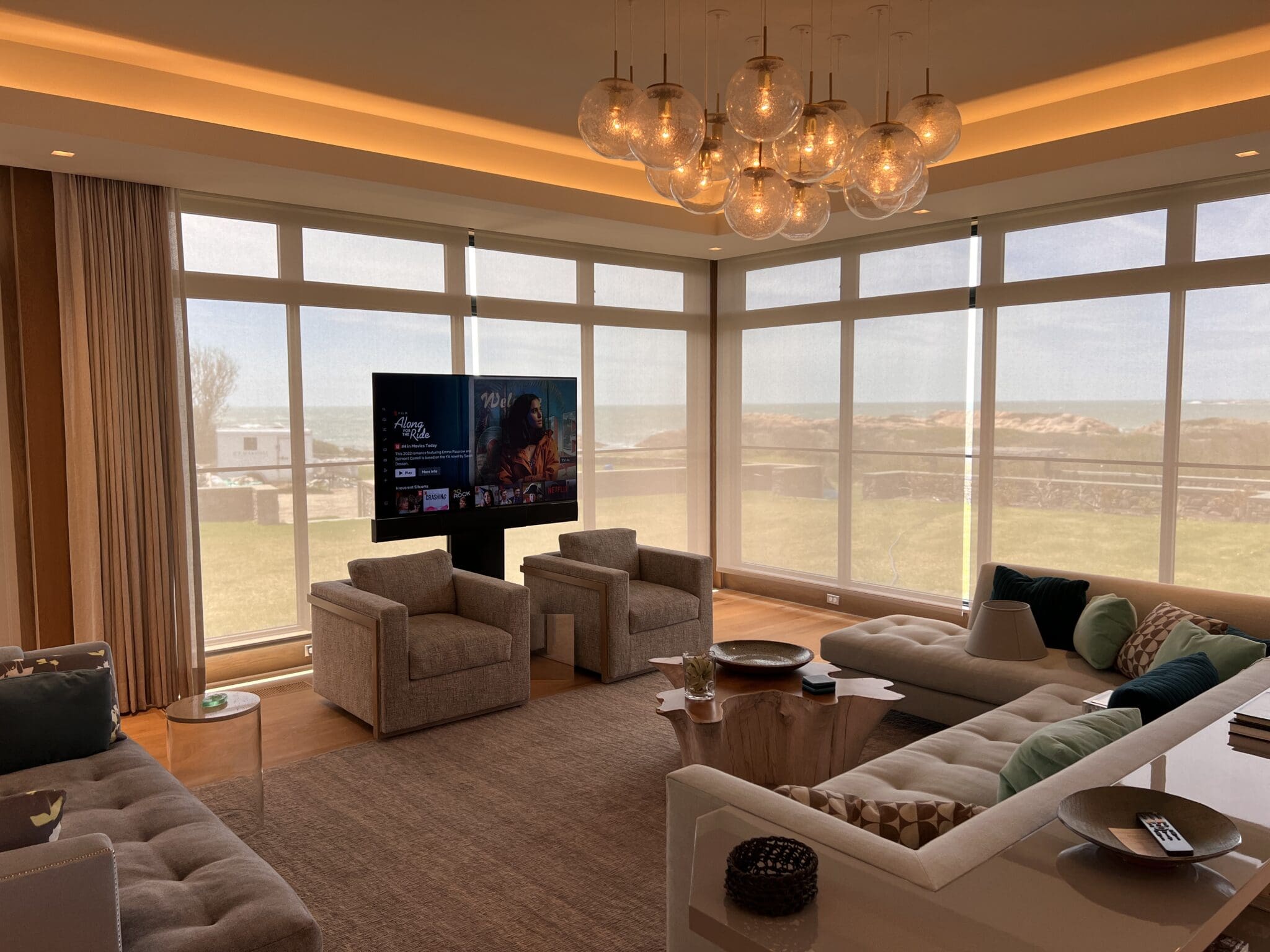 Living room with a TV on a lift and ocean view in Little Compton, RI