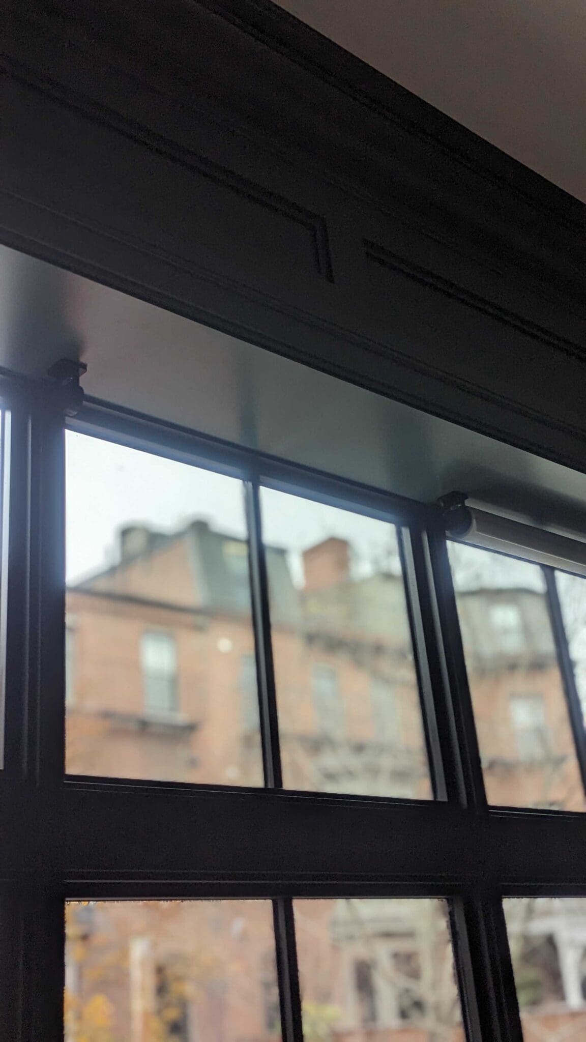 Tall black-framed windows looking out on South End brownstones