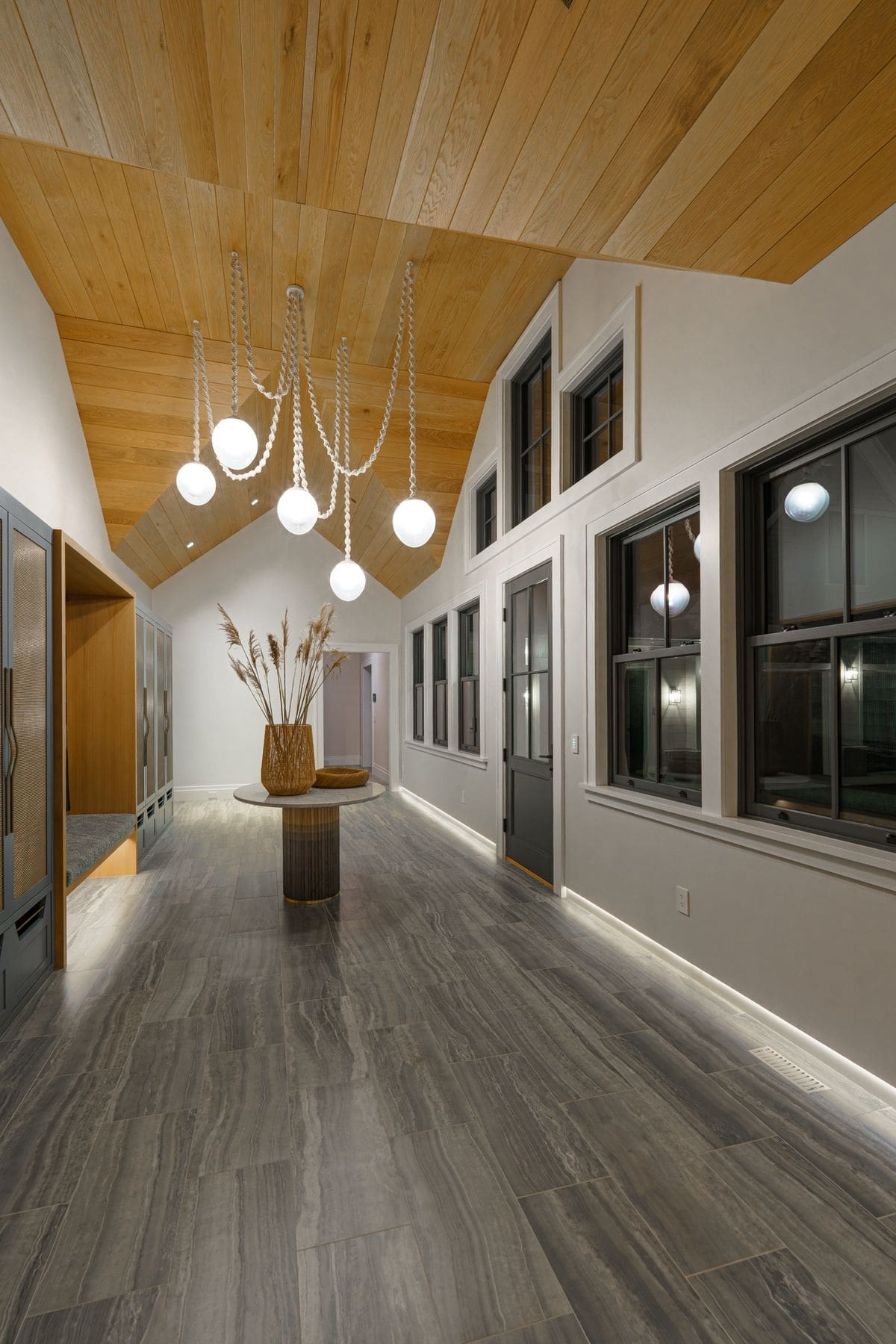 Entry gallery with vaulted cedar ceiling and sculptural pendant lighting at a Narragansett oceanfront home