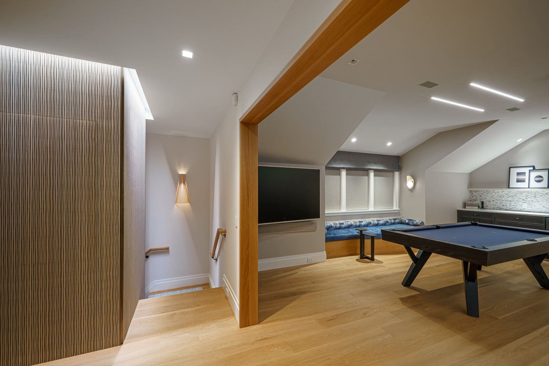 Game room entry framed in cedar with reeded wood millwork and concealed lighting