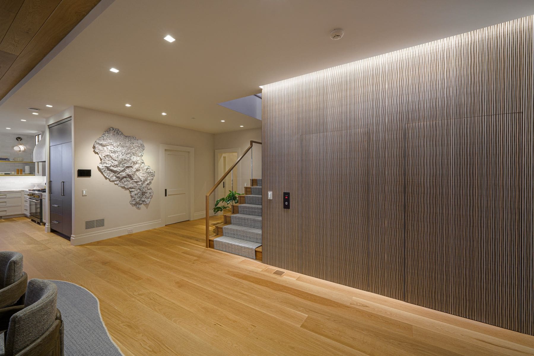 Great room with reeded wood millwork concealing a residential elevator, keypad flush-mounted alongside