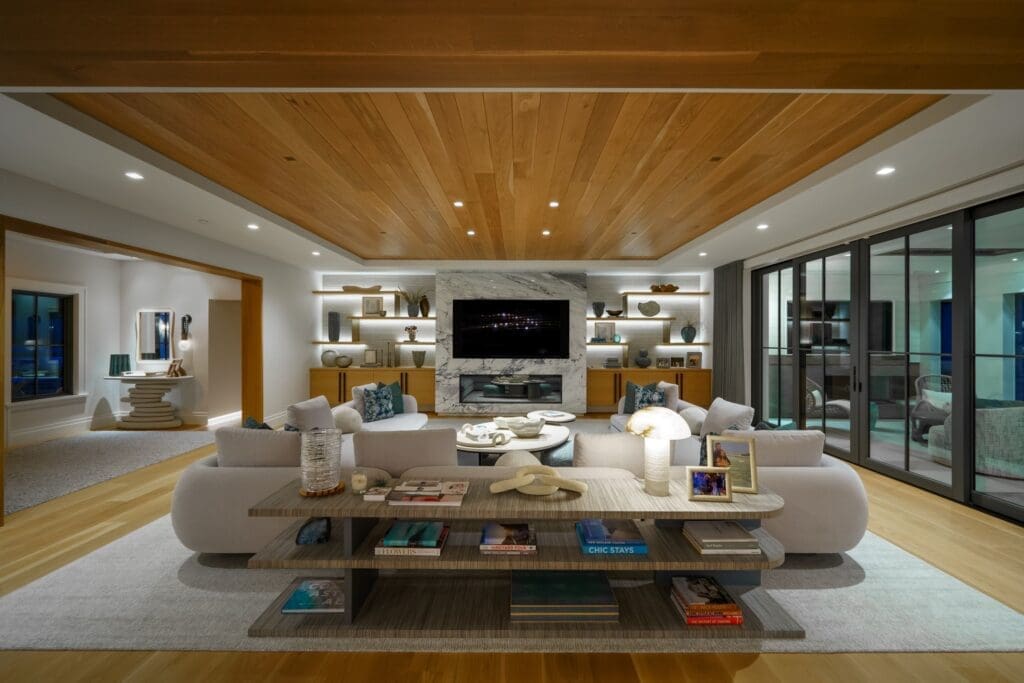 Oceanfront living room with cedar plank ceiling, marble fireplace and a Sony Bravia OLED display flanked by backlit shelving