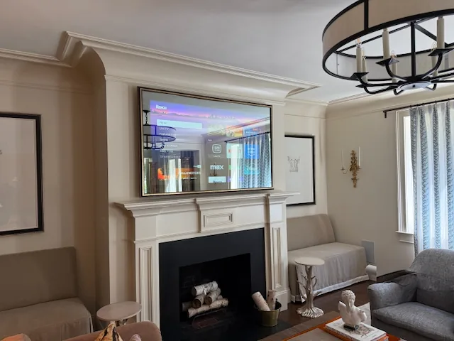 Formal living room with a TV built in above the fireplace
