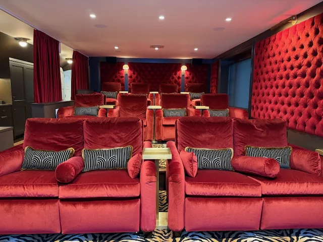 Private cinema with red velvet seating and tufted walls in a Needham, MA home